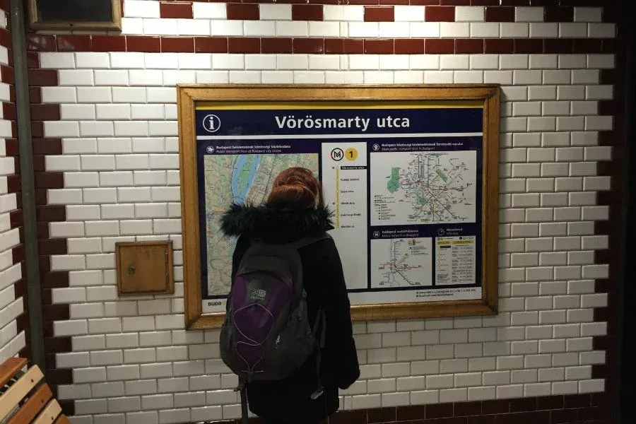 Jade inspects the mero map at Vörösmarty utca station.